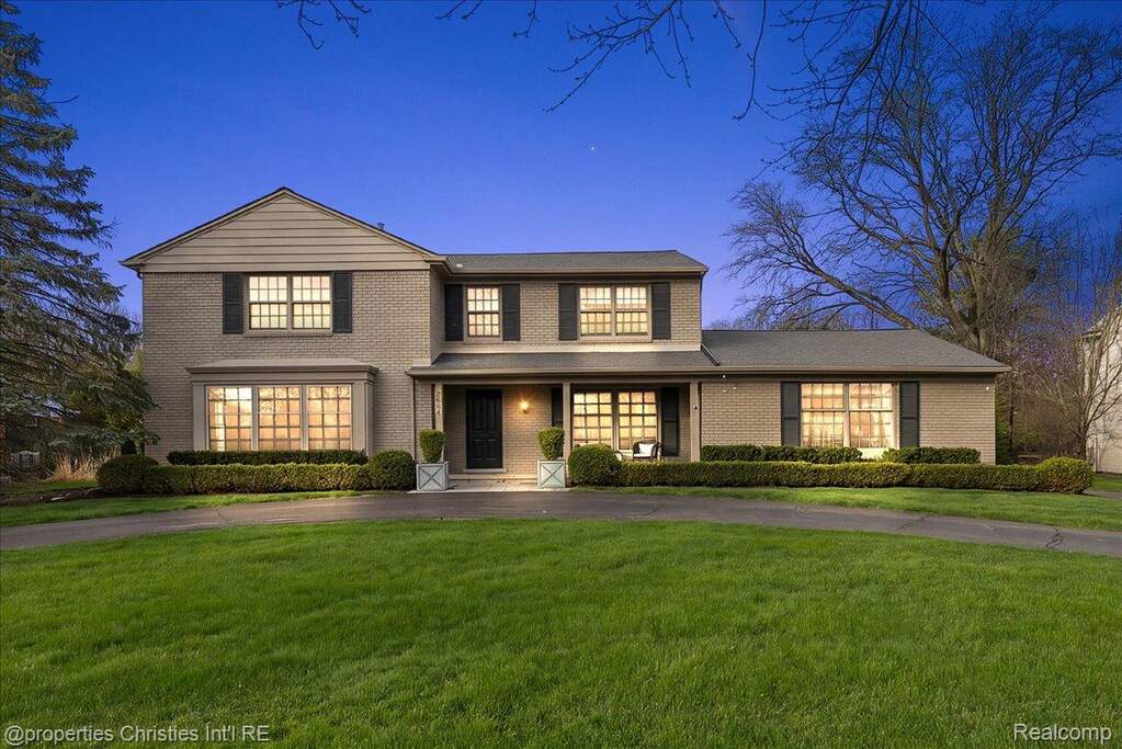 Traditional-style house with covered porch, brick siding, and a front yard