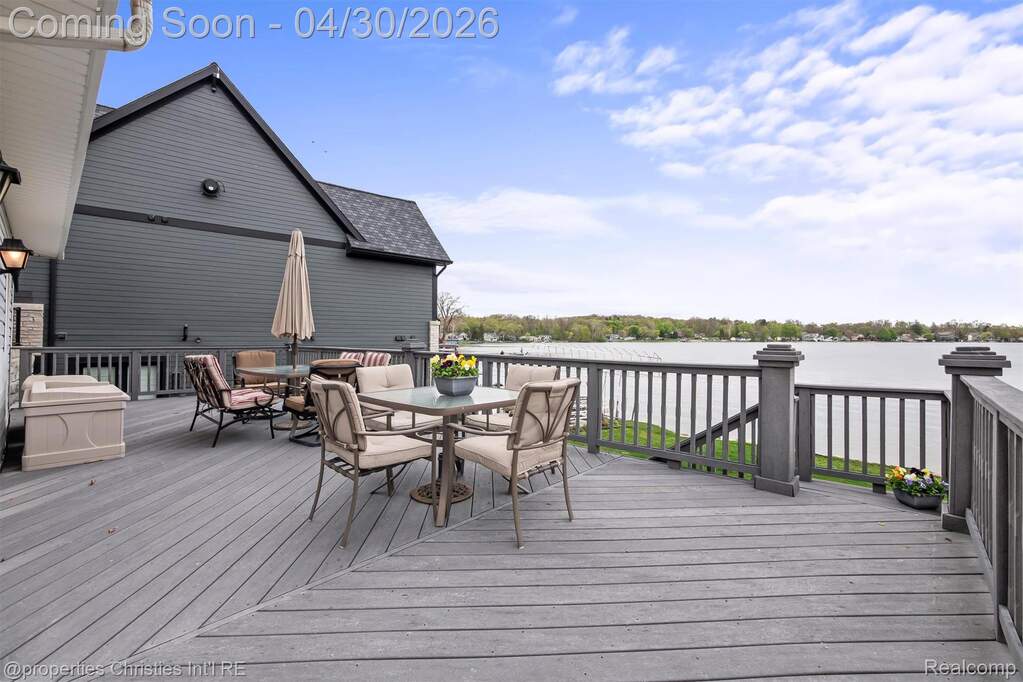 Easy care composite deck with outdoor dining space and a lake view.