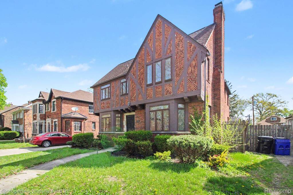 English style home with brick siding and a chimney