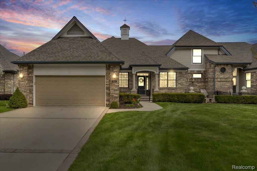 View of front of house featuring a garage, a front yard, driveway, and a shingled roof