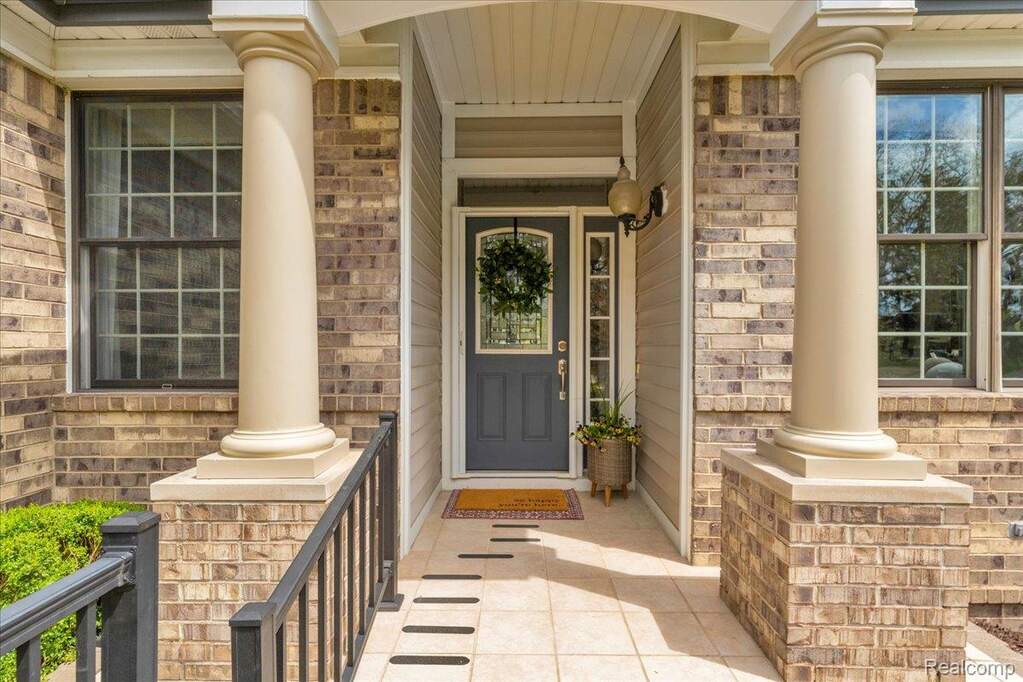 Property entrance with covered porch and brick siding