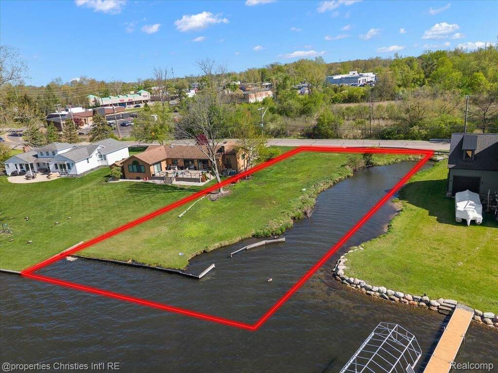 Waterfront lot featuring a grassed landscape with direct water access