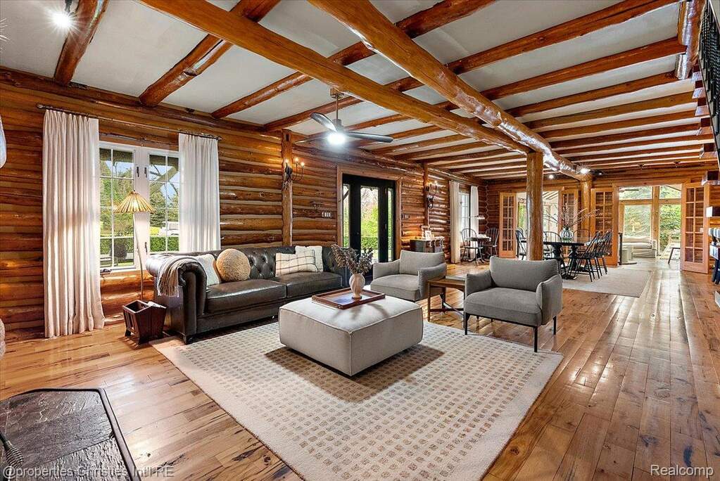 Living room with plenty of natural light, hardwood / wood-style floors, beam ceiling, and log walls