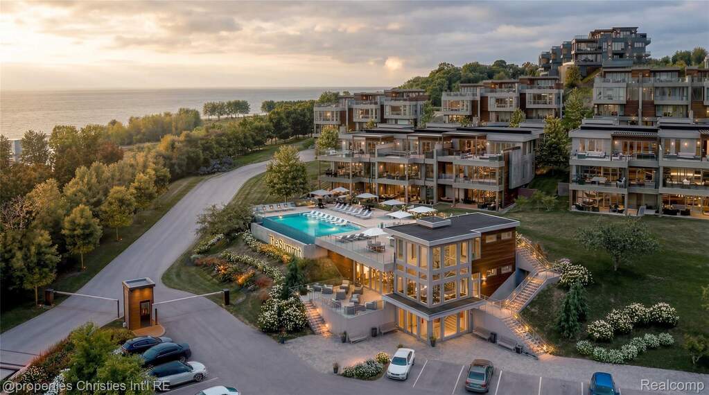 Terraced waterfront residences featuring contemporary architecture, expansive balconies, an outdoor swimming pool, and a dedicated entry with mature landscaping