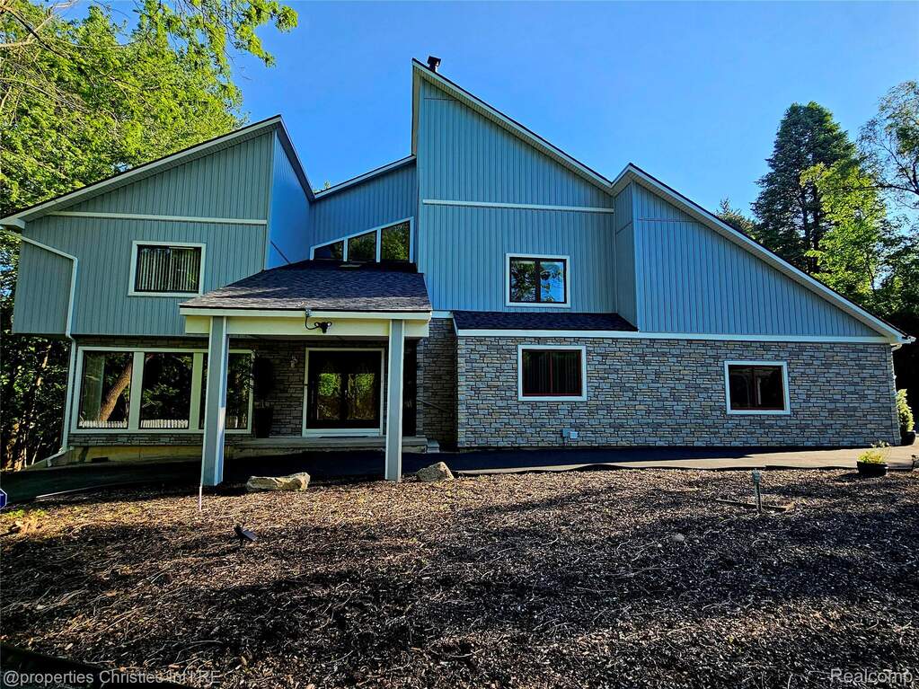 View of front facade featuring stone siding and a porch