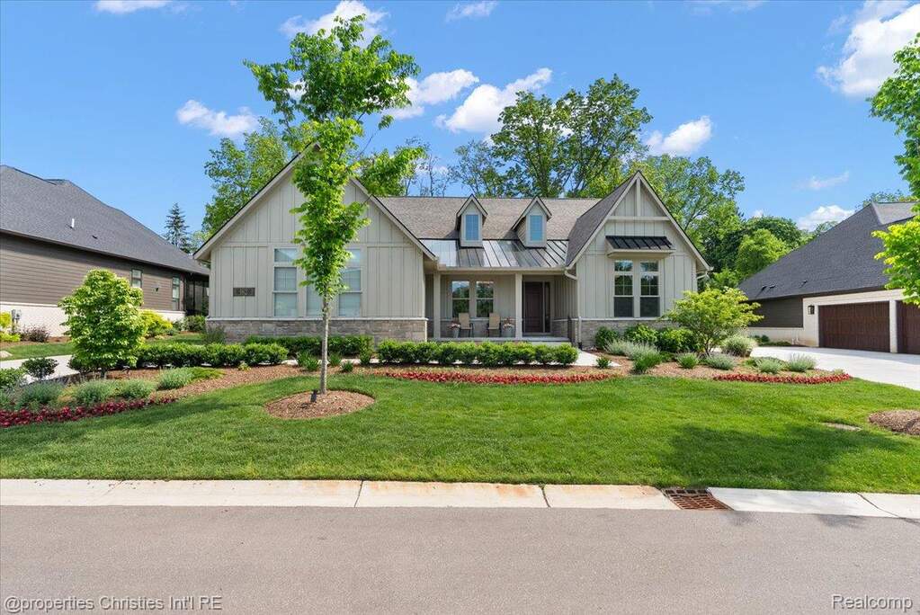 Craftsman-style home featuring board and batten siding, stone facade, and a covered porch