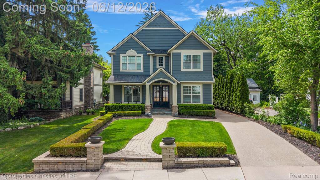 Two-story residence featuring blue siding with white trim, a gabled roofline, and a prominent portico