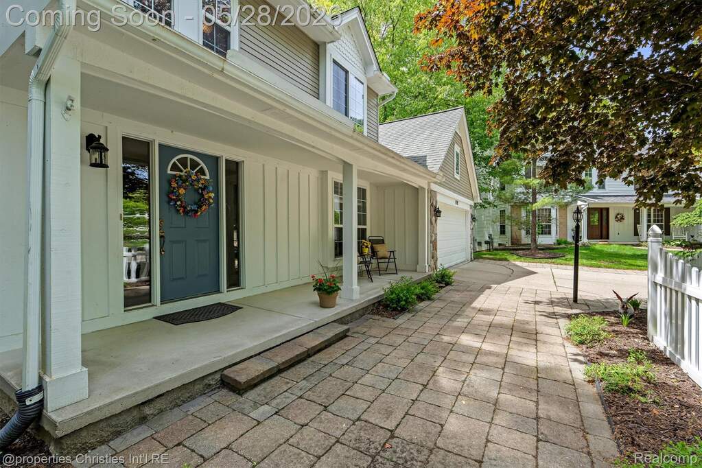 View of exterior entry featuring covered porch, board and batten siding, concrete driveway, and roof with shingles