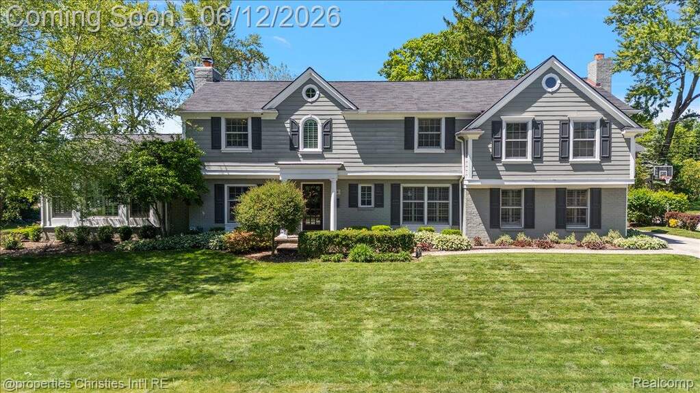 Traditional two-story residence with a gray siding exterior and coordinating gray brick accents