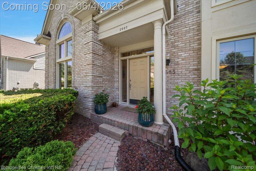 Brick facade featuring a columned portico entry with a transom window