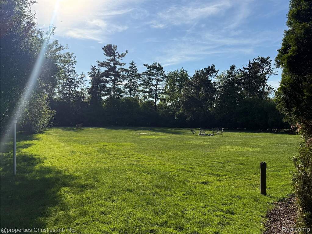 Expansive lawn featuring mature perimeter trees and natural light