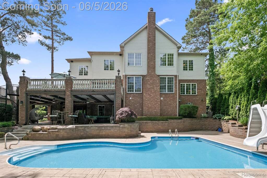 In-ground swimming pool with integrated steps, surrounded by stamped concrete decking