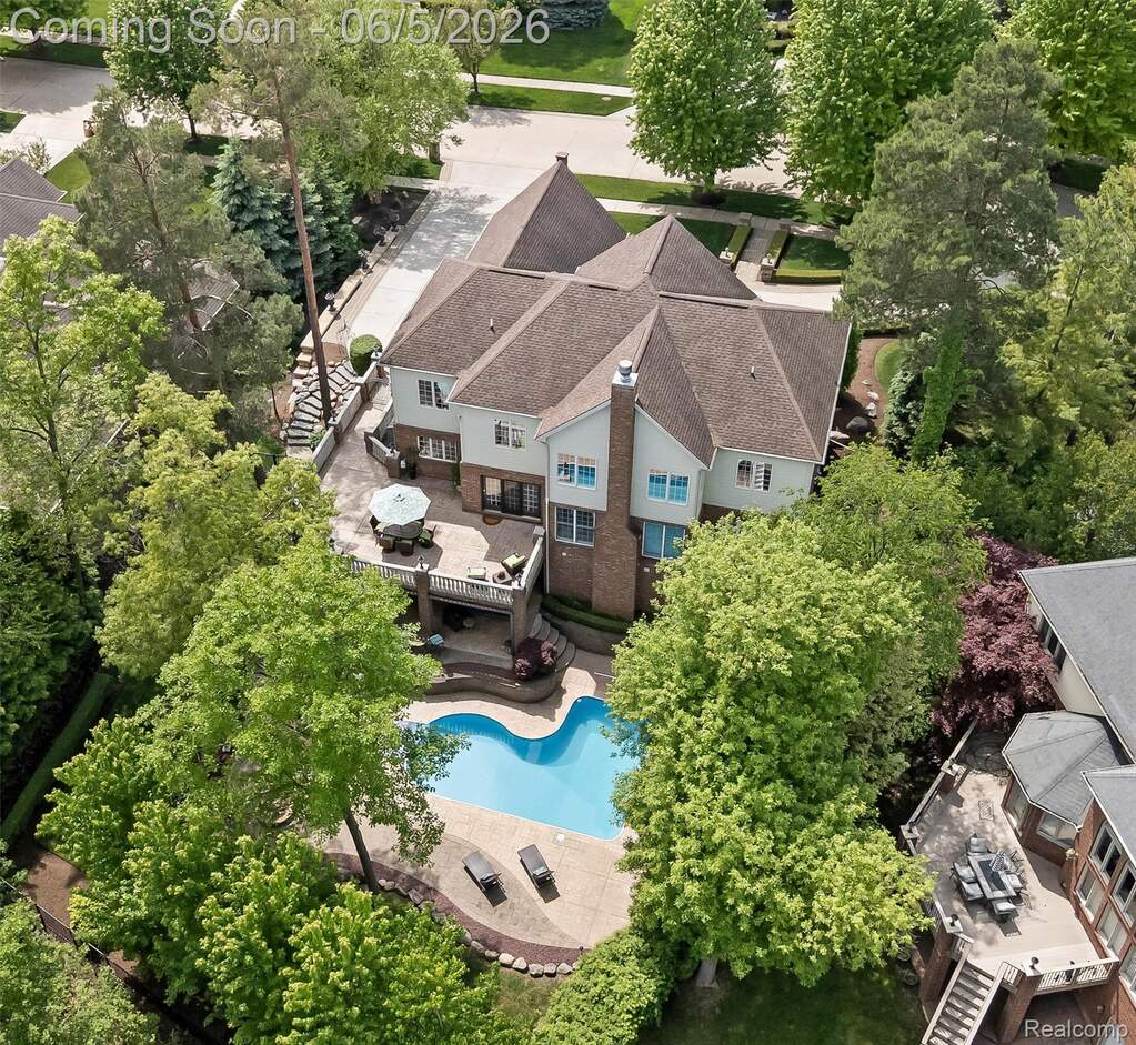 Residential property with a multi-level design, featuring a large, free-form inground swimming pool