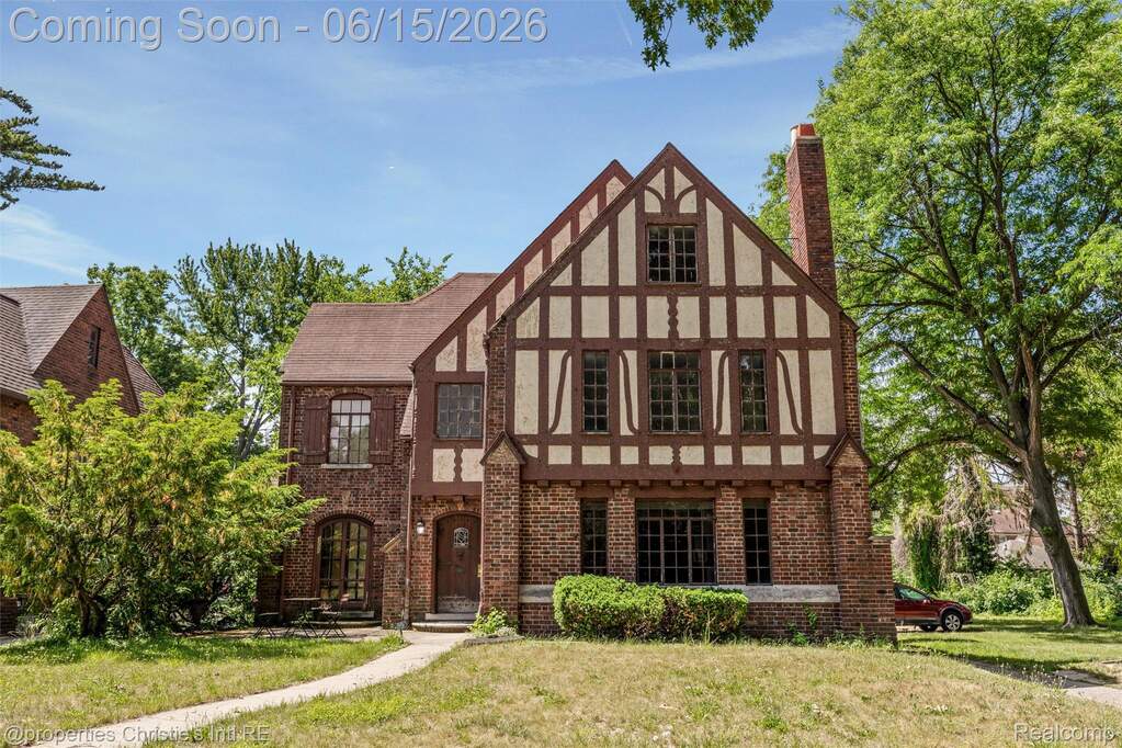 Tudor-style residence featuring brick and half-timbered facade, multiple gables, and a prominent brick chimney