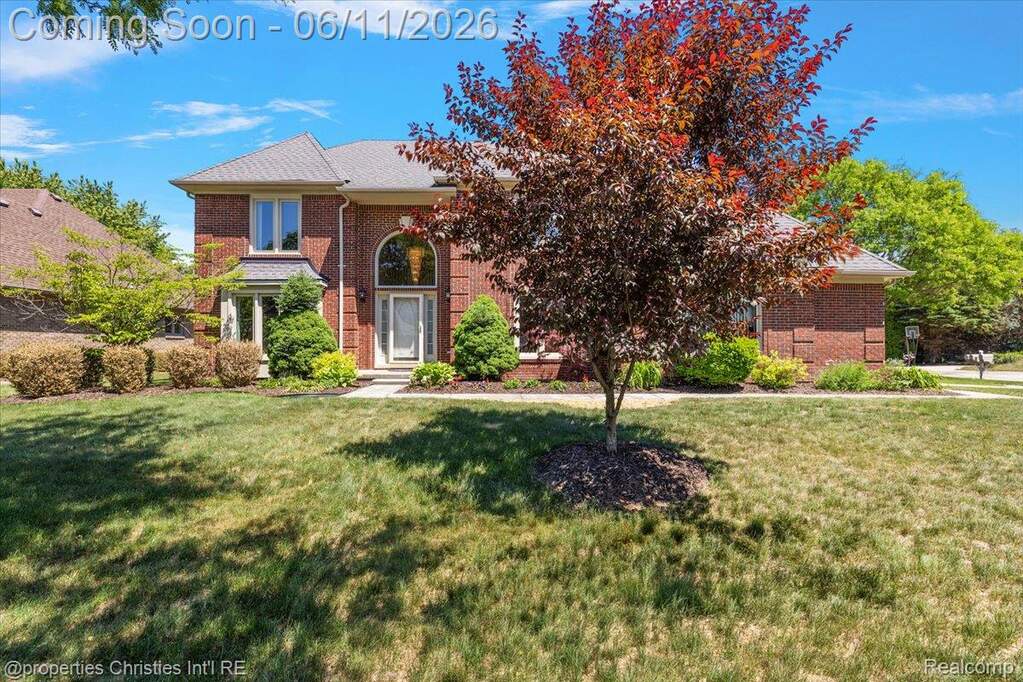 Traditional brick exterior with a prominent arched entry and a decorative transom window