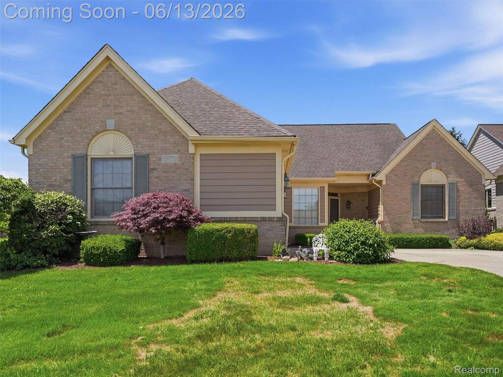 Brick exterior with contrasting siding accents, a prominent front gable, arched window detail, and dark shingle roofing