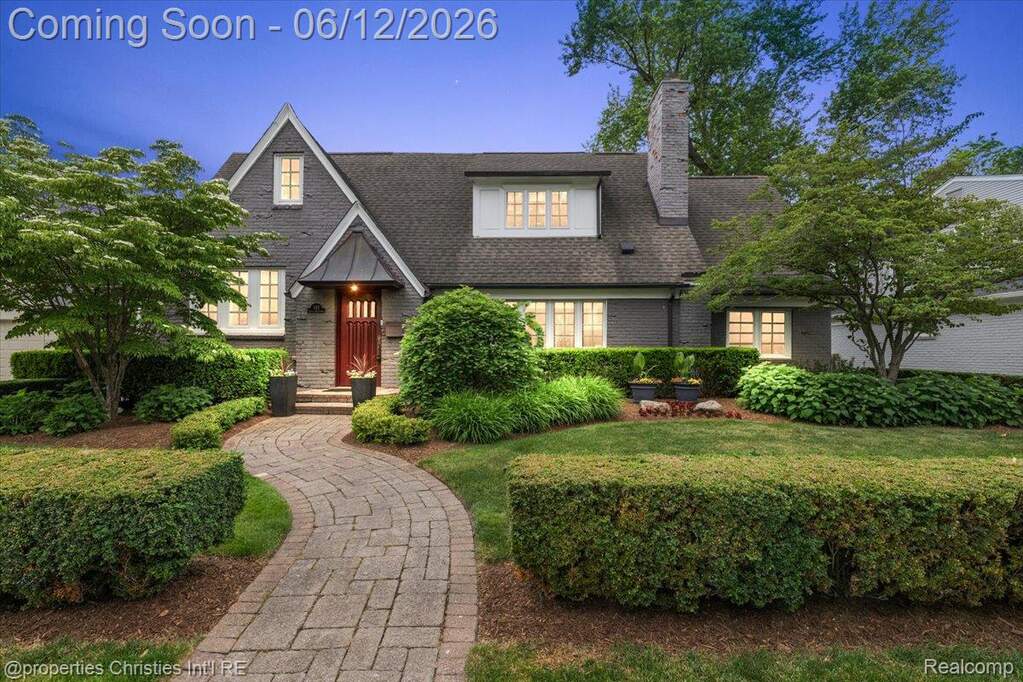 Distinguished brick residence featuring a prominent red entryway door