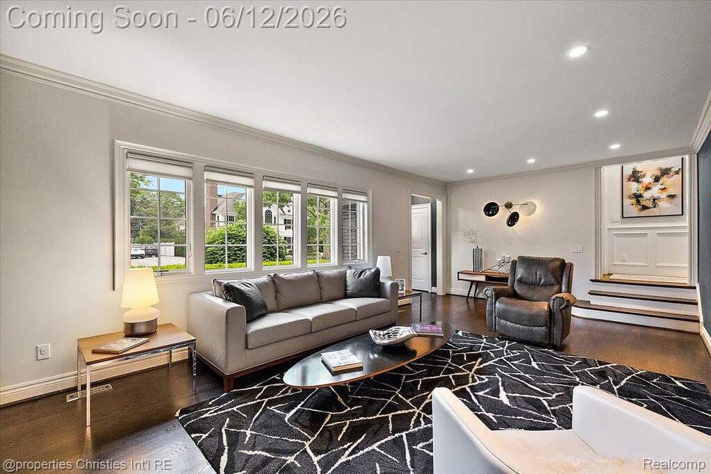 Open living area featuring dark wood-finish flooring, recessed lighting, and crown molding