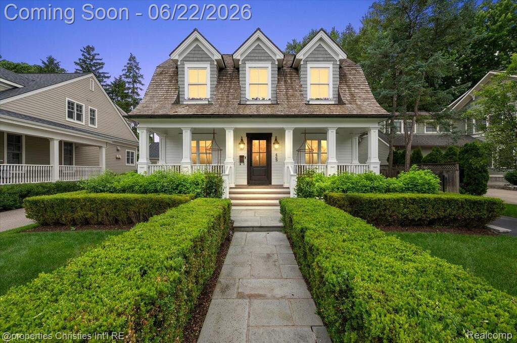Classic American Foursquare architecture featuring a shingle roof, dormer windows, and a covered porch
