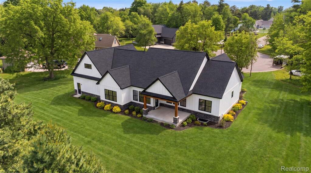Contemporary farmhouse architecture featuring white vertical siding and a dark shingled roof