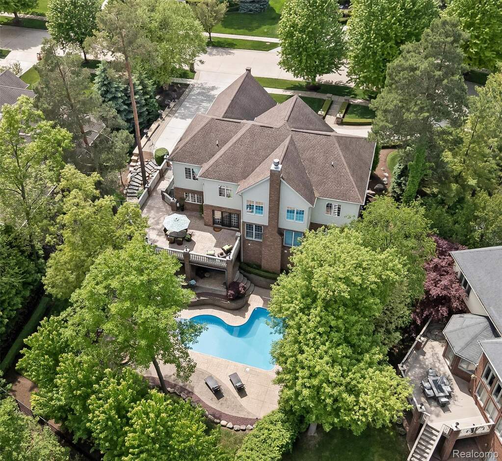 Residential property with a multi-level design, featuring a large, free-form inground swimming pool