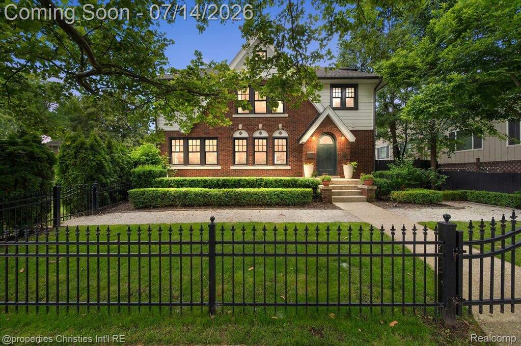 Brick and siding exterior featuring an arched entryway with stone steps