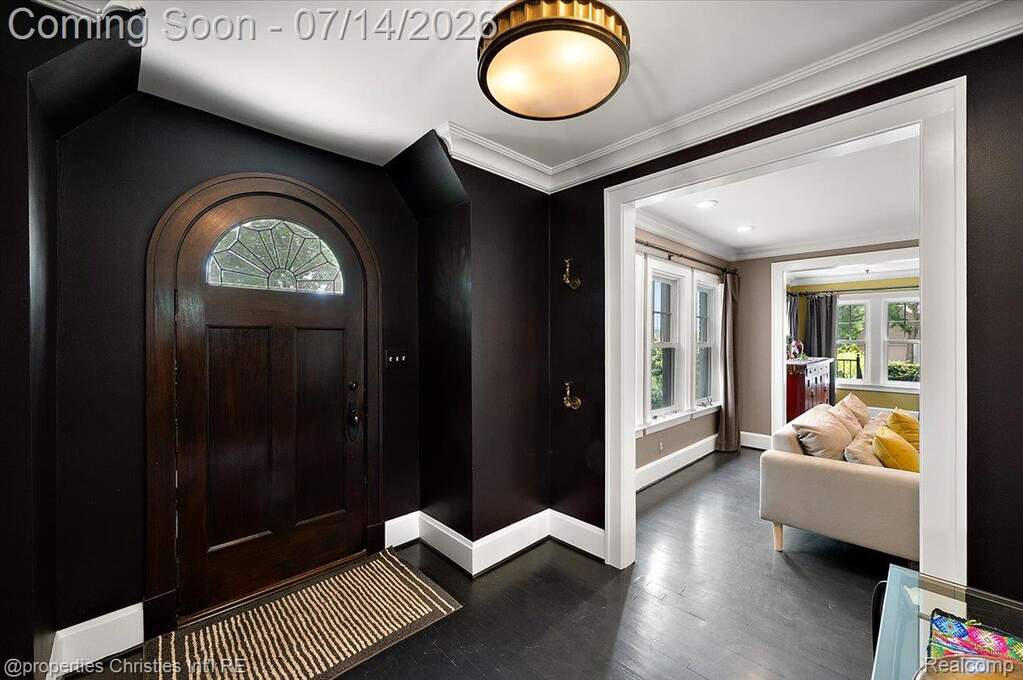 Arched wooden entry door with leaded glass transom
