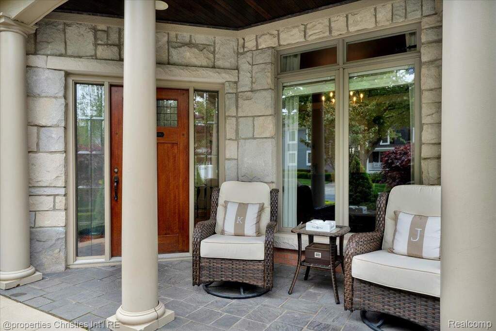 View of exterior entry with stone siding and a porch