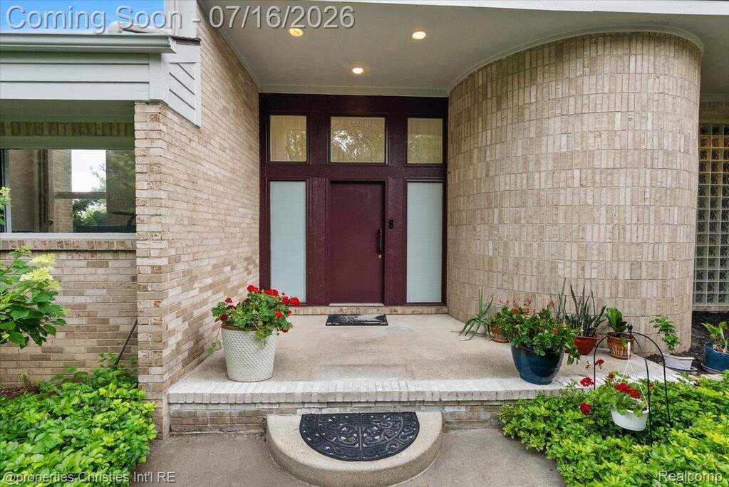Brick exterior with a prominent burgundy entry door, transom windows, and frosted sidelights