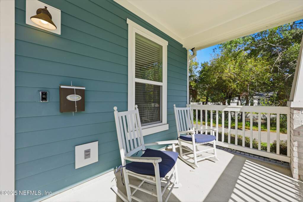 Front Porch – Covered porch with space for seating features clean white railings and overhead lighting, creating a welcoming outdoor retreat.
