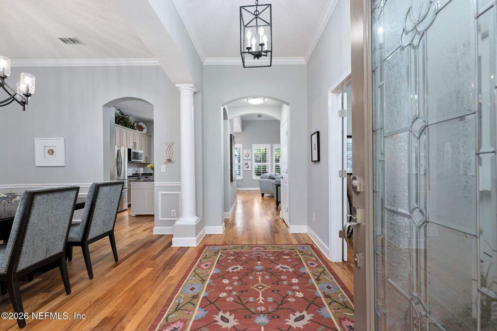 Leaded glass door leads to a wow home with architectural details throughout