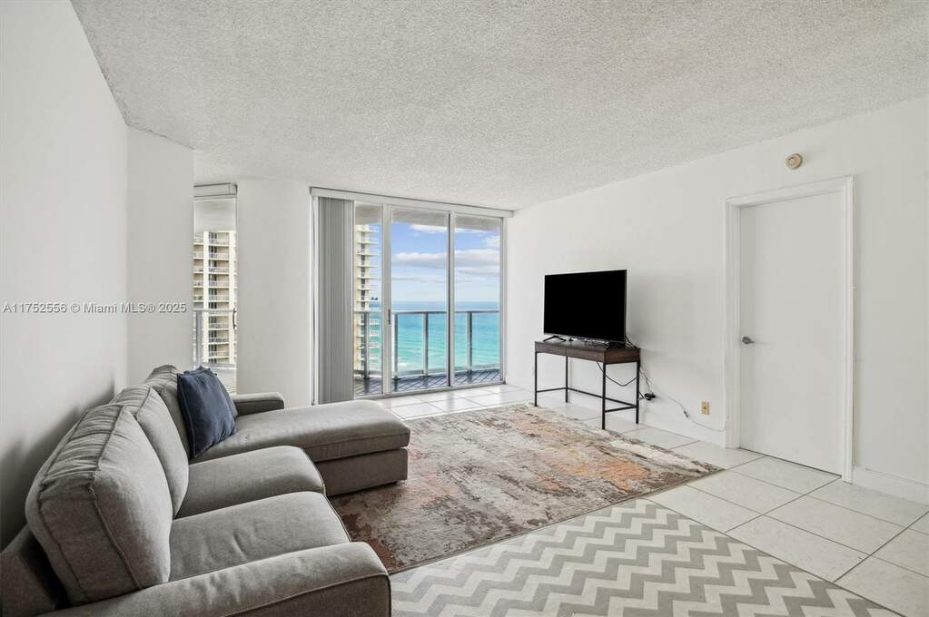 Open Layout Living Area with Entrance to Balcony.