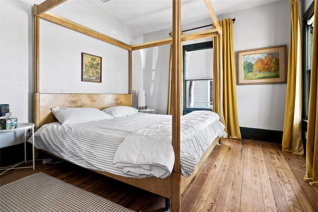 Spacious and quietly charming, this bedroom blends clean lines with vintage touches and natural light from multiple windows.