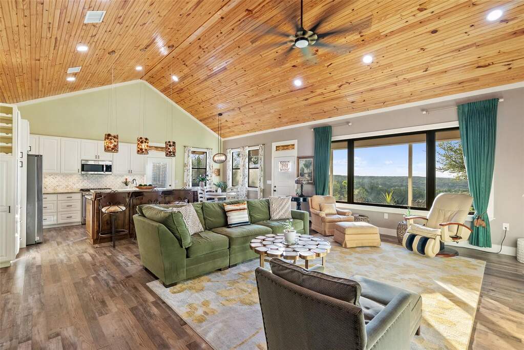 The main house living/dining/kitchen area's backdrop is the beauty of the hill country