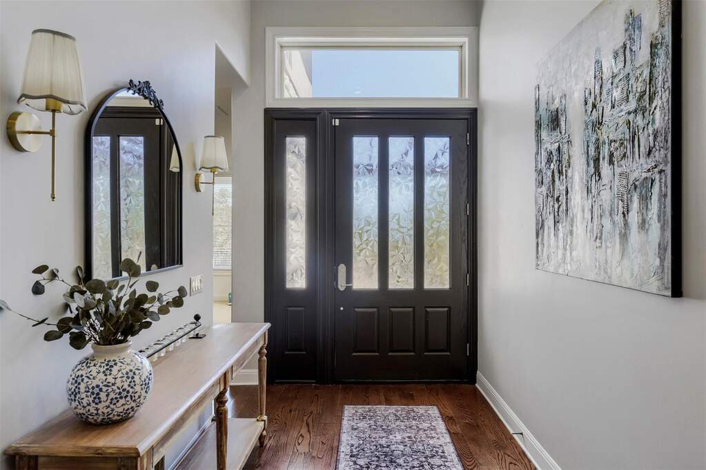The front entry makes a beautiful first impression with its completely redone front door, featuring fresh paint, new glass panels, and updated exterior lighting