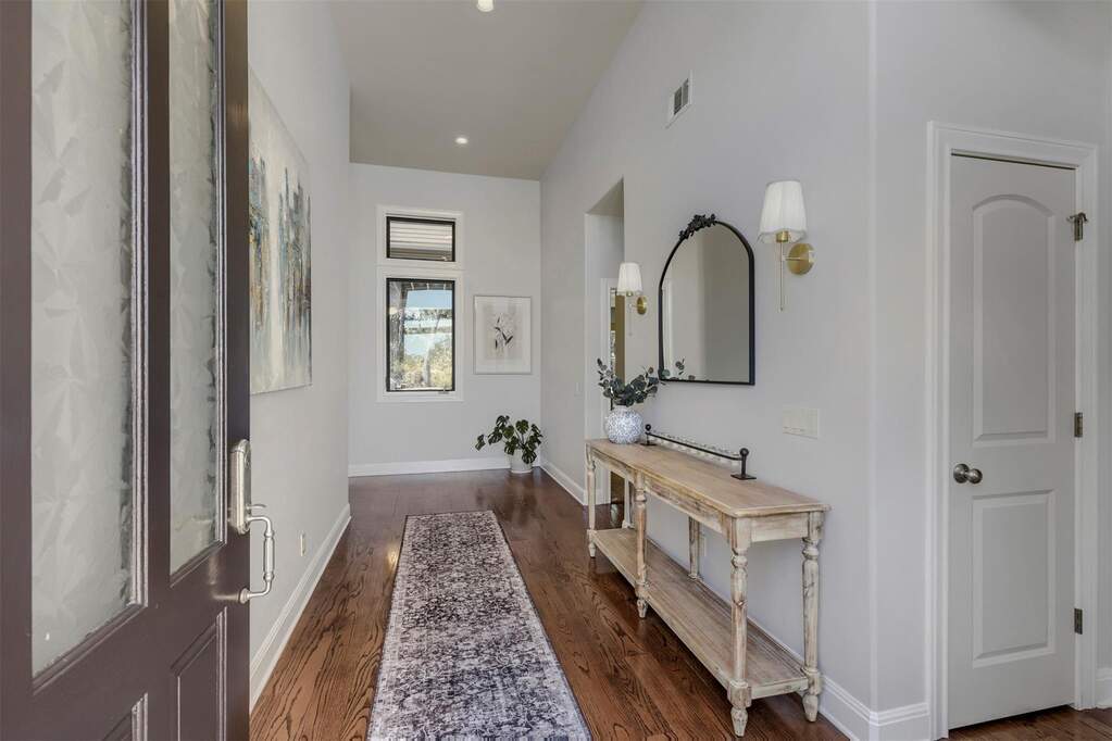 Step into the foyer where the layout immediately shows its strengths; the staircase leads to the second floor, while the primary suite and main-floor guest room sit just down the hall
