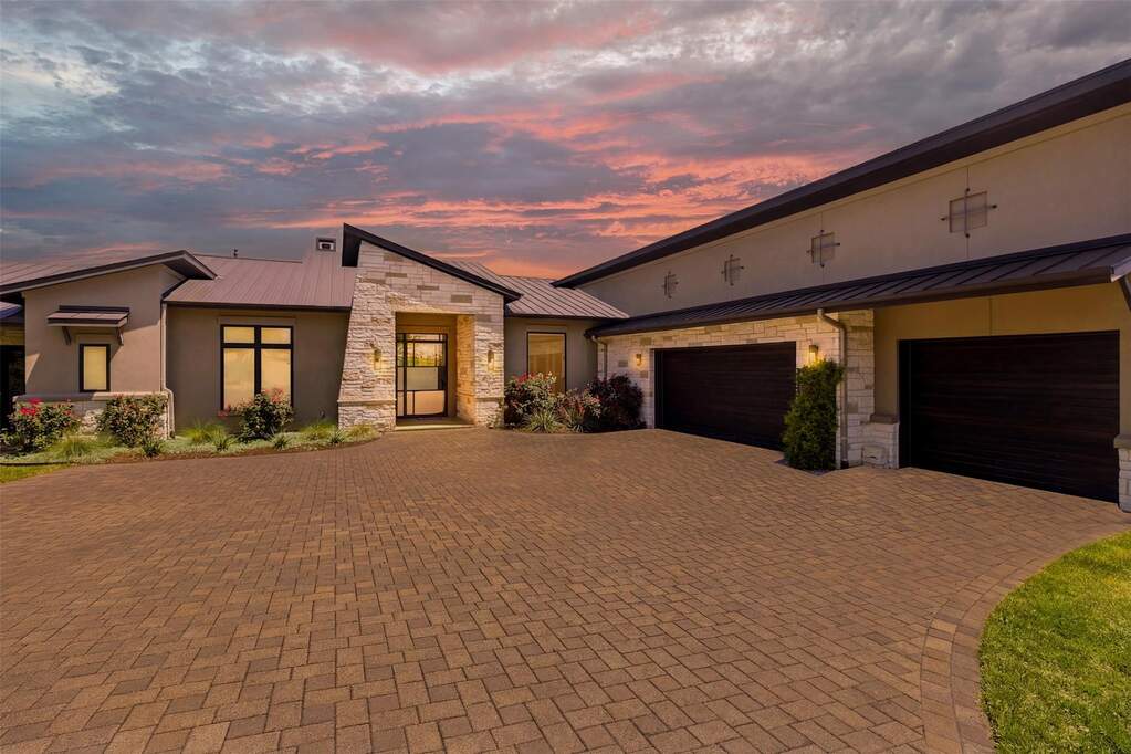 The arrival sets the tone immediately, with a striking blend of stone and stucco, a metal roof, and a thoughtfully designed approach that feels both grounded and architecturally bold.