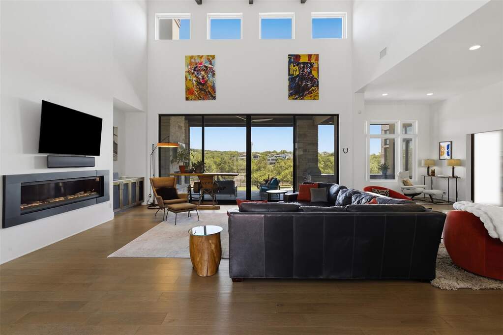 Inside, vaulted ceilings and exposed wood beams immediately establish a sense of scale, bringing warmth and architectural depth to the main living space.