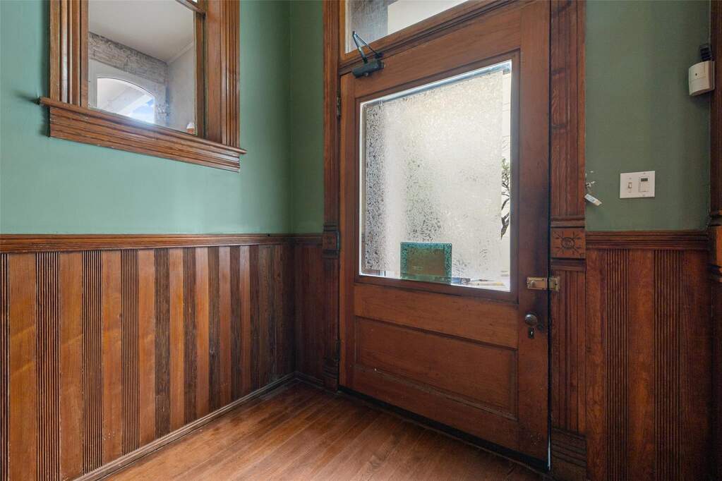 Entryway with a wainscoted wall, wooden walls, and wood finished floors
