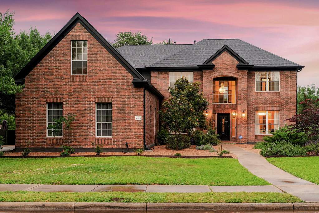Brick facade with a prominent gabled roofline creates an inviting curb appeal.