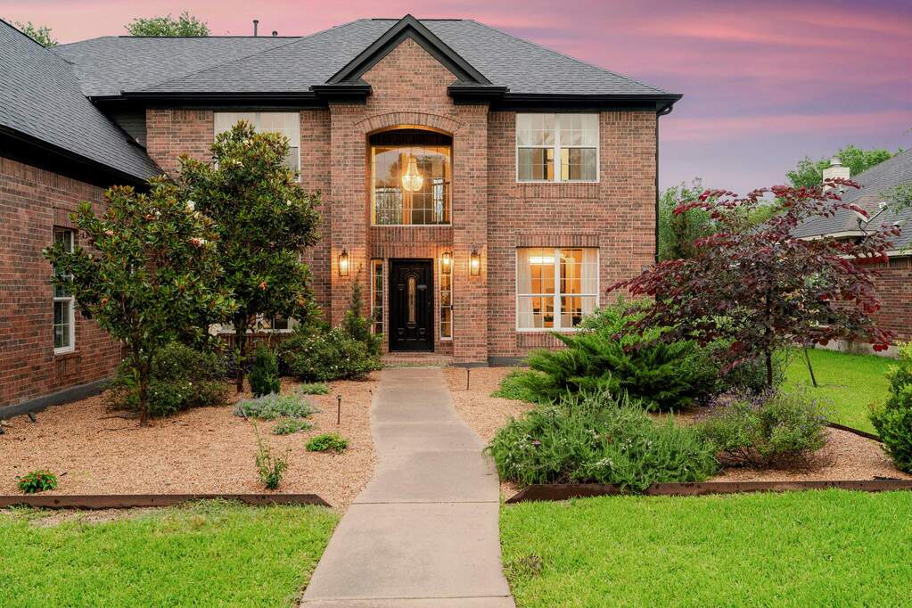 A classic brick exterior, framed by thoughtful landscaping, welcomes you home.