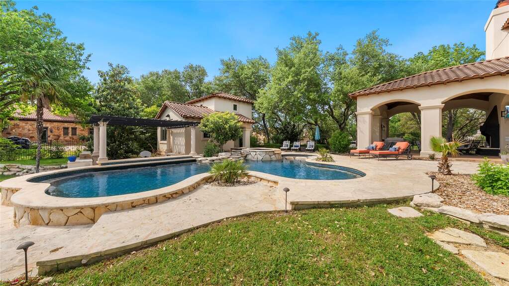 Resort style backyard with pool, spa, swim up bar, pergola, and multiple covered living areas