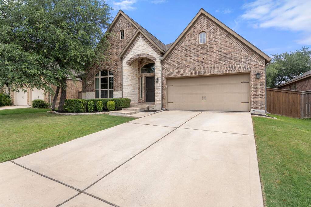A two-car garage paired with an inviting front walkway establishes great curb appeal in the heart of the Bryson community