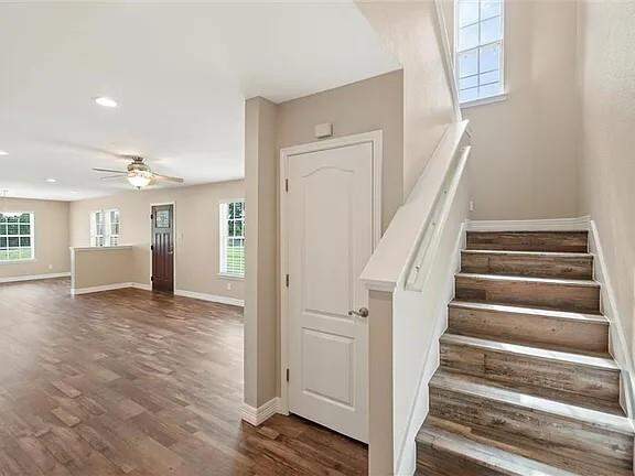 Staircase with a ceiling fan, wood finished floors, and recessed lighting
