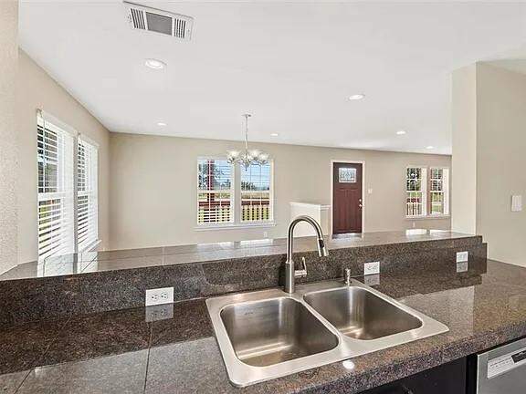 Kitchen featuring a chandelier, recessed lighting, stainless steel dishwasher, open floor plan, and pendant lighting