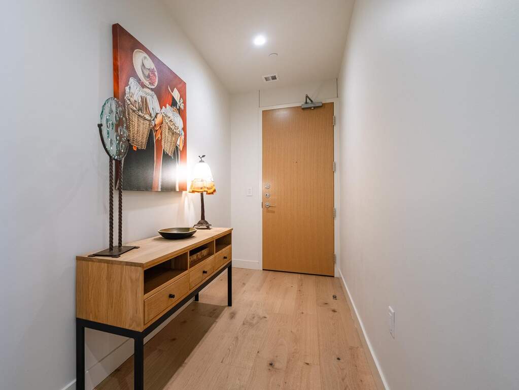 The property features light-toned hardwood flooring, white walls, and a recessed ceiling light