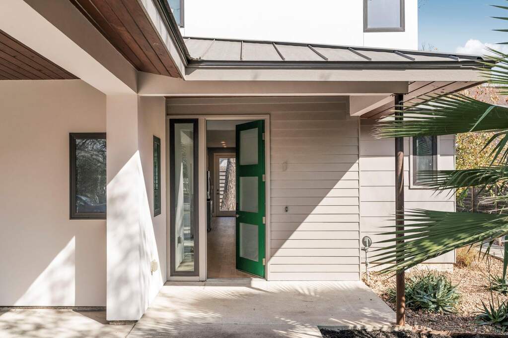 Modern lines, a metal roof, and bold black-framed windows create serious curb appeal from the moment you arrive.