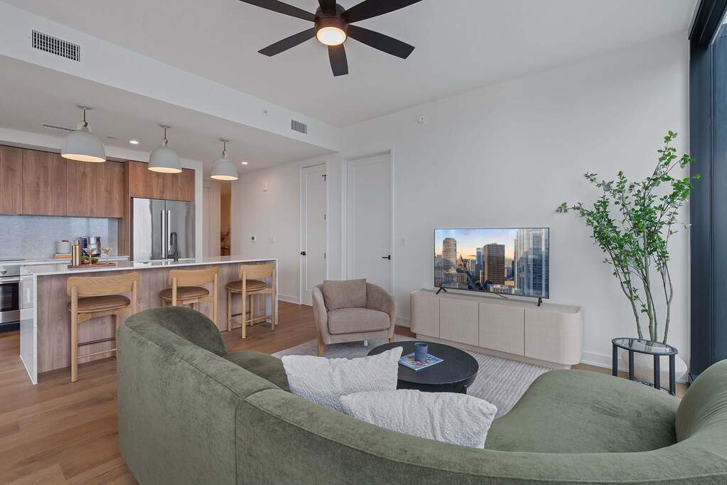 Representative Photo. Open Concept living room with 7.5" wide Bella Cera hardwood flooring, recessed lighting, ceiling fan, and a balcony off the living room with a North West view