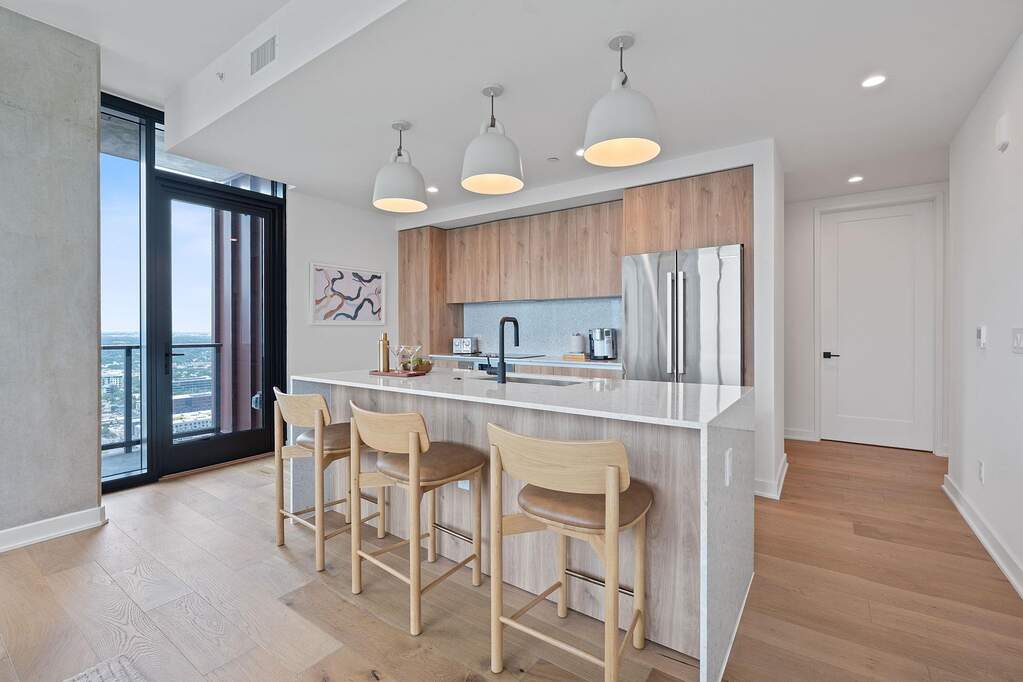 Representative Photo. Kitchen featuring custom Italkraft cabninetry, terrazzo backsplash, waterfall-edge terrazzo countertops, stainless steel Bosch appliances, and pendant lighting above kit