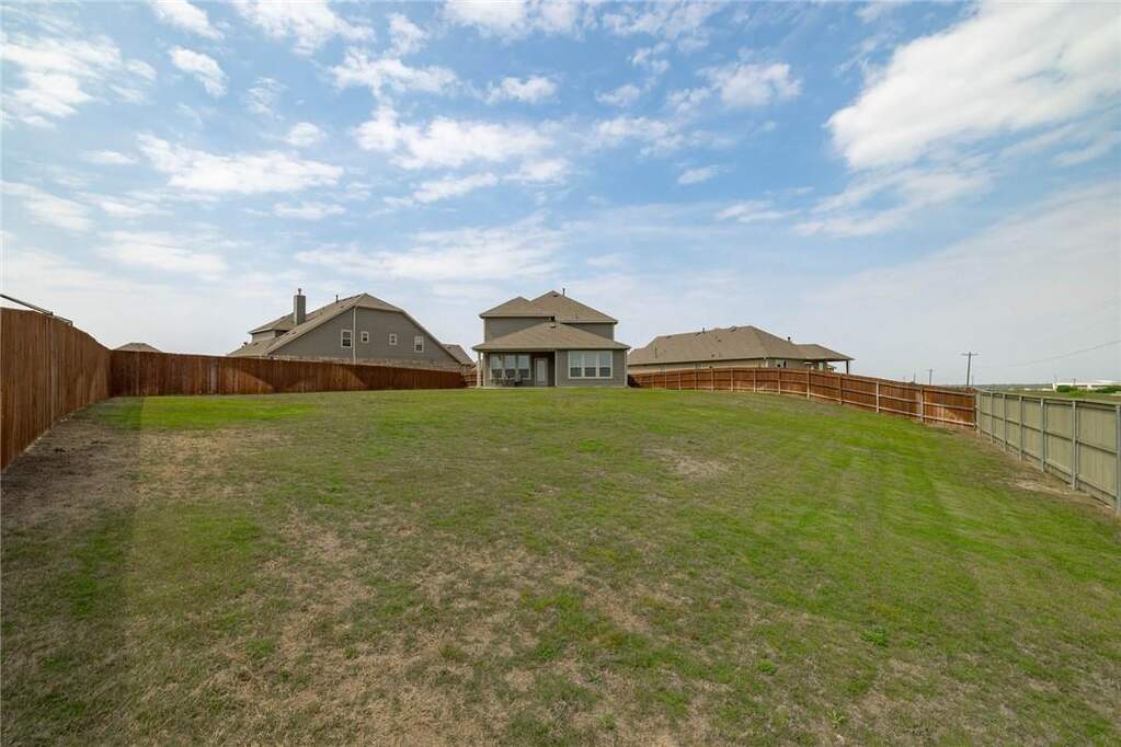 Expansive backyard featuring a partial wood fence and a partial light-toned privacy fence